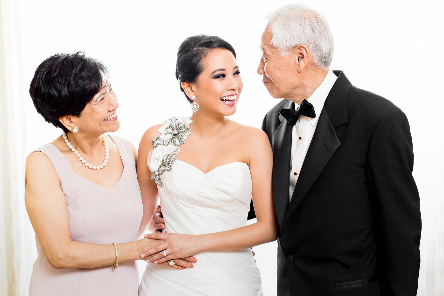 This was a beautiful moment between a bride and her parents, Mom is staring lovingly at her daughter and dad is all smiles, The bride is in between them and they look so happy and in the moment, This was taken in Bethesda Maryland. They are Asian. Procopio Photography, best top Washington DC photographer, best top Maryland photographer, best top Virginia photographer, best top DMV photographer, best top wedding photographer, best top commercial photographer, best top portrait photographer, best top boudoir photographer, modern fine art portraits, dramatic, unique, different, bold, editorial, photojournalism, award winning photographer, published photographer, memorable images, be different, stand out