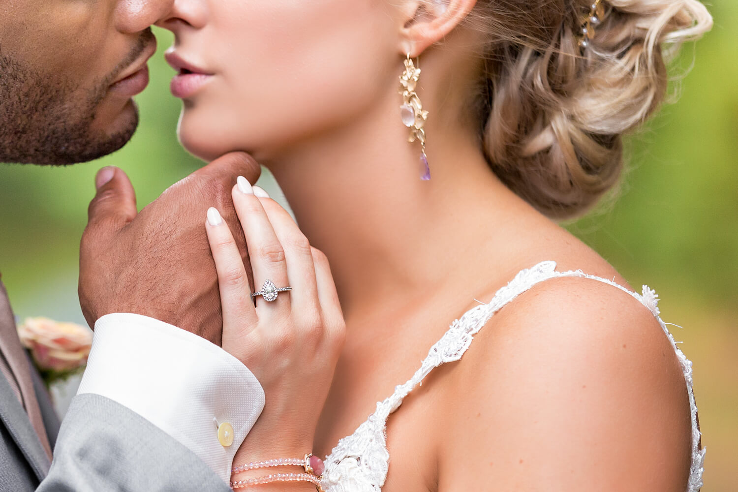 This is a close up of a bride and groom almost kissing, she has a teardrop diamond ring, her pink lips and white wedding nails stand out, black groom, white bride, grey suit, eastern shore wedding